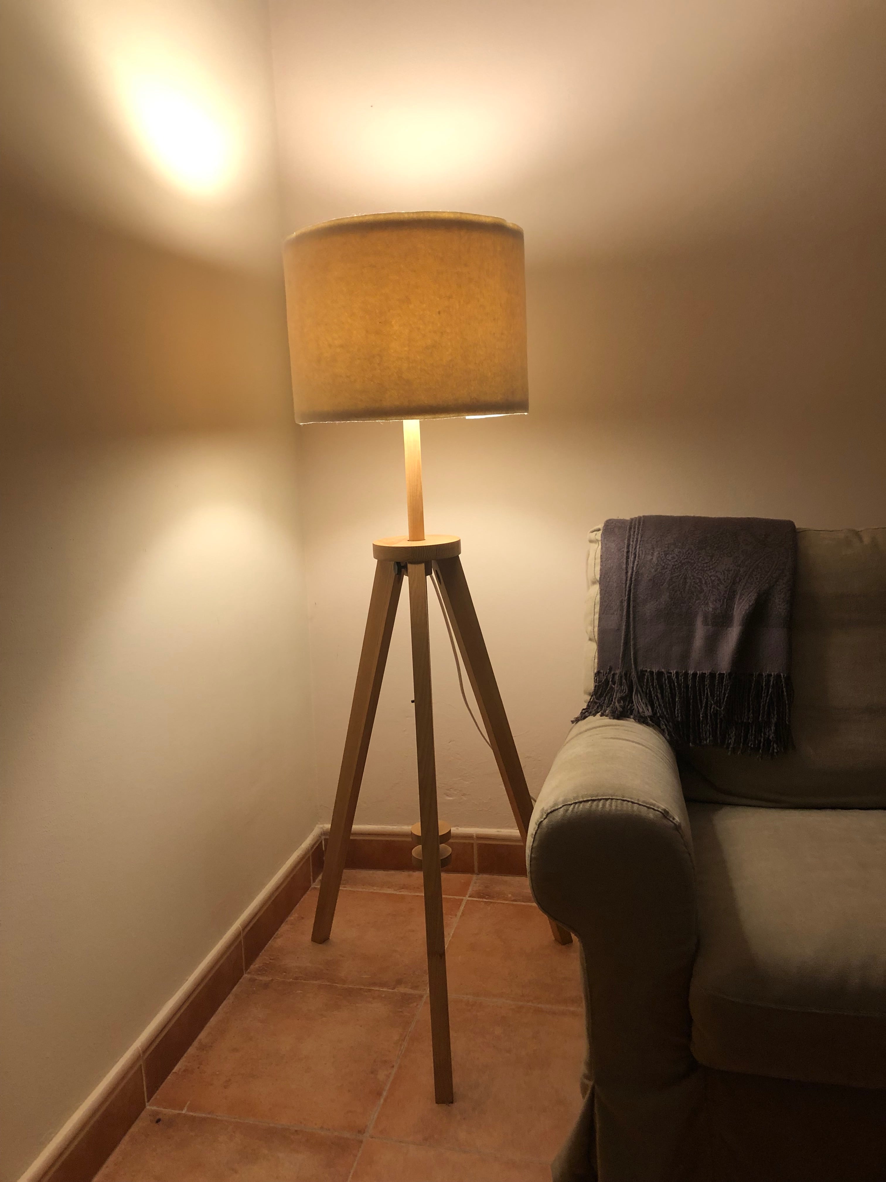 Natural wool lampshade on wooden floor lamp in rustic living room, warm lighting for mountain homes and boutique hotels